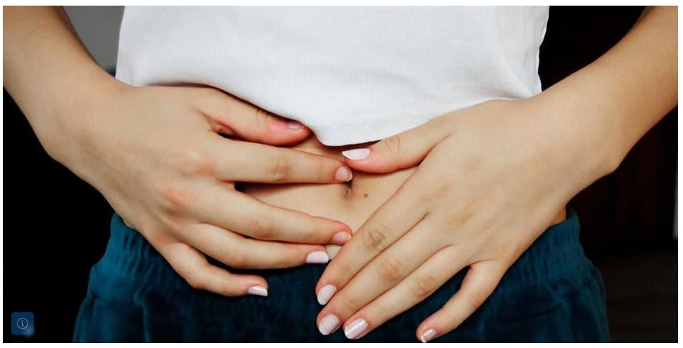 Frau hält sich schmerzhaft den Unterbauch bei Endometriose.